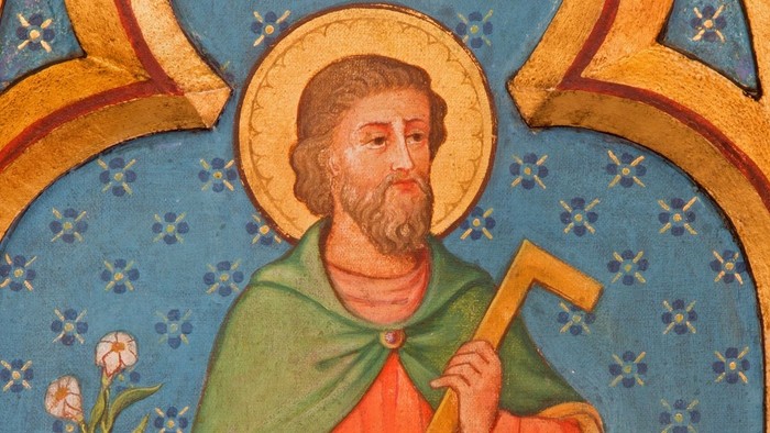 Mittelalterliches religiöses Gemälde eines bärtigen Heiligen mit einer Spitzhacke, Heiligenschein und blumigem Rahmen.