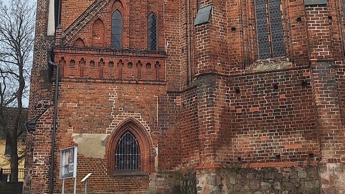 Gothische Backsteinkirche mit hohem Turm und spitzem Dach