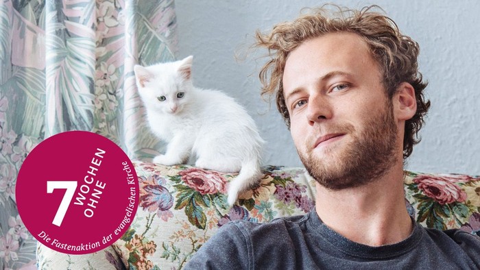 weiße Katze und Mann auf einem Sofa