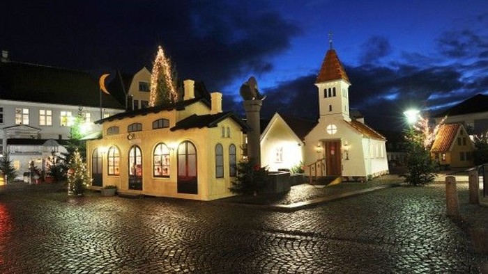En lille by med lyssatte hus og kirke om natten
