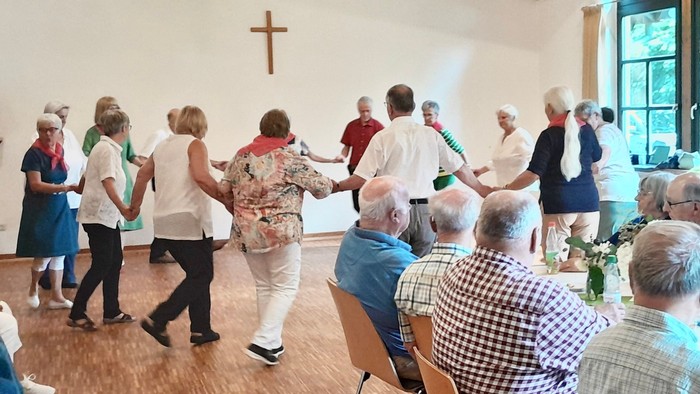 Gruppe älterer Menschen, die in einem Gemeindehaus tanzen