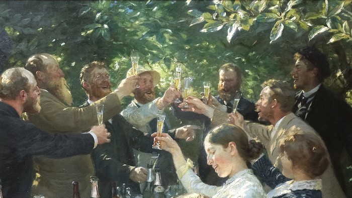 En gruppe af mennesker hygger sig ved et festligt bord i en have