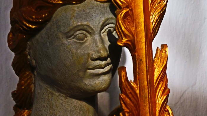 Guldstatue af kvinde med fjer.