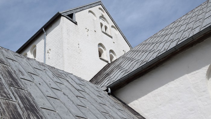 Toet af et hvidt tårn med spiret og taget.