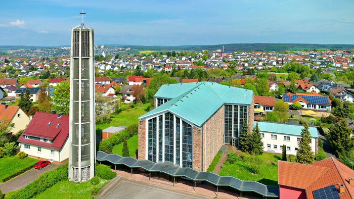 Ein moderner Gebäudekomplex mit hohem Turm und umliegender Wohnsiedlung