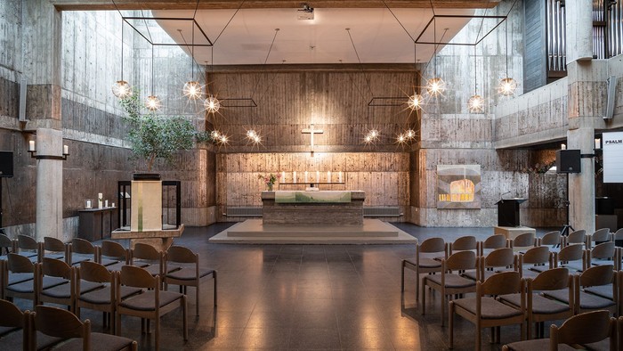 Modernes Restaurant mit hohen Decken, großen Fenstern und Holzstühlen