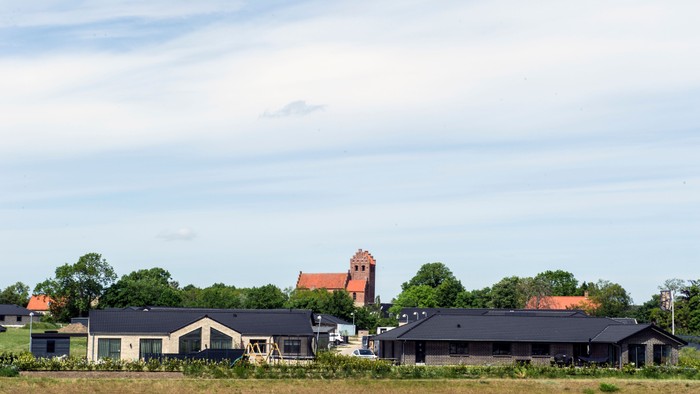 En landsby med flere huse og en kirke i baggrunden