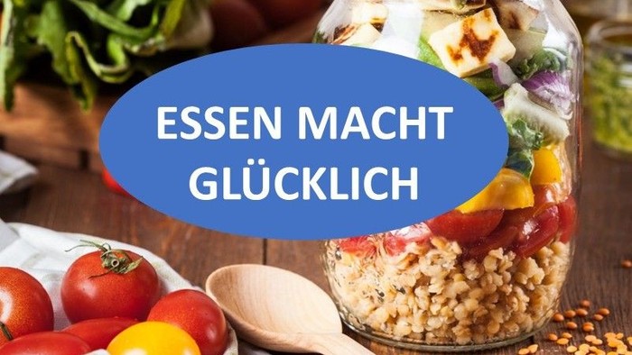Gesunde Mahlzeitenvorbereitung mit frischem Gemüse, Getreide und einem Holzlöffel, betont „Essen macht glücklich“.
