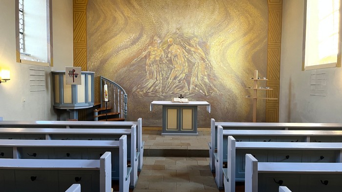 Kirchlicher Innenraum mit Altar und Kirchenbänken