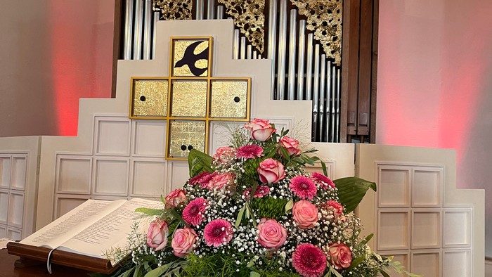 Blumenstrauß auf Tisch vor Altar in Kirche