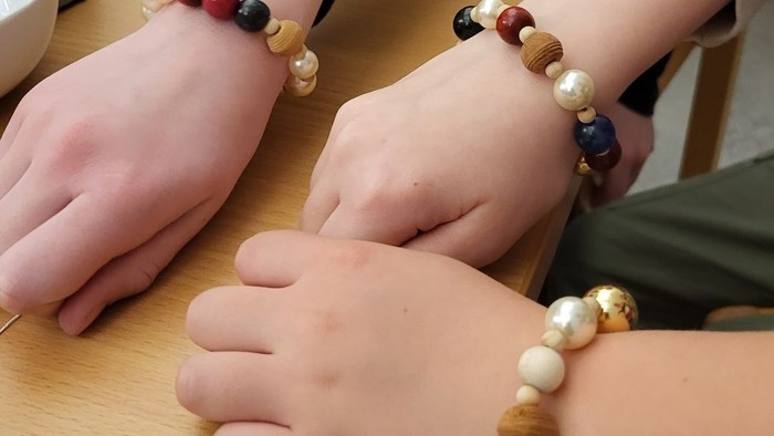 To børn med armbånd af perler og trækugler.