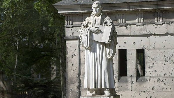 Statue eines Mannes mit Buch vor einem Gebäude