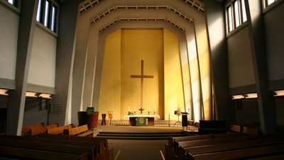 Innenraum einer Kirche mit Kreuz und Kirchenbänken