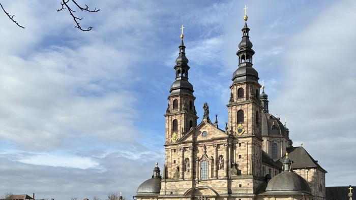 Werbeschild für Fulda mit einem Herz und dem Stadtnamen vor dem Hintergrund einer historischen Kathedrale.