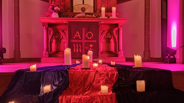 Der Altar der Stadtkirche. Davor Tücher und Kerzen auf dem Boden
