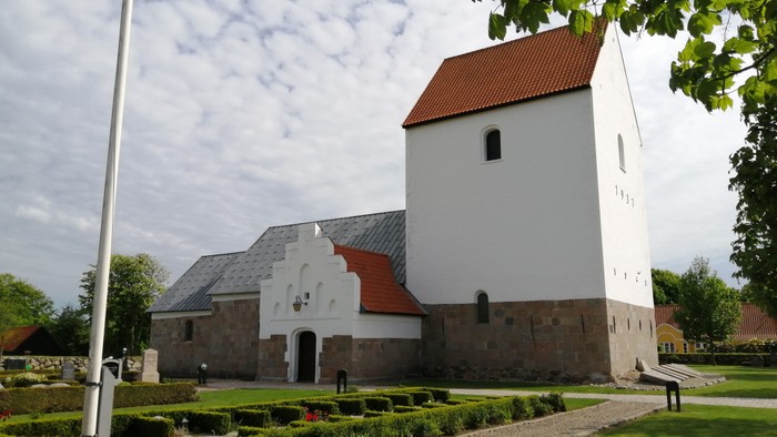 Tolstrup Kirke fras nordsiden, flagstangen og små hække foran