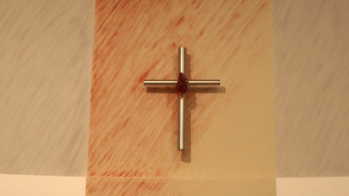 Ein Kreuz an einer Marmorwand