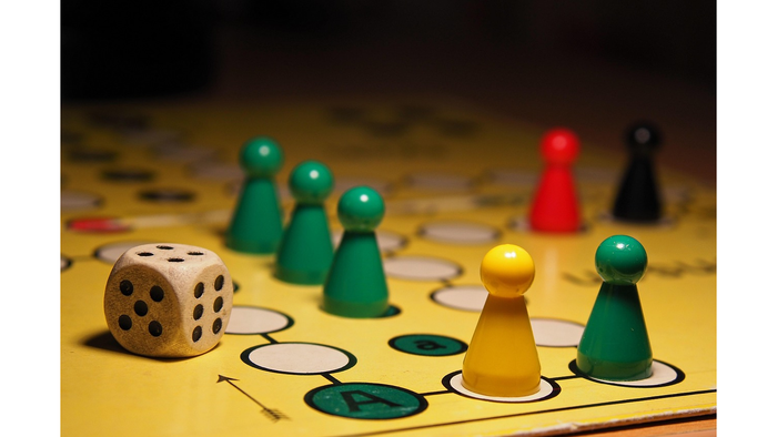 Spielsteine und Würfel auf einem Spielbrett