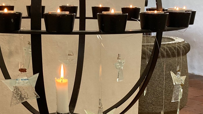 En kandleholder med flere lysende lygter og glasdekorationer.