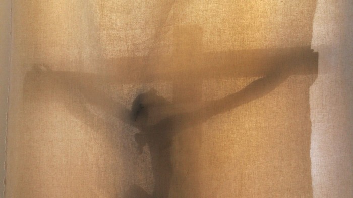 Kreuz hinter einem Vorhang