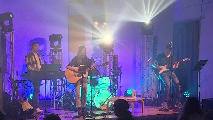 Eine Band spielt auf einer Bühne vor einem Publikum