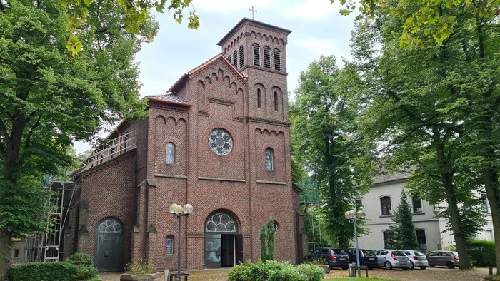 Antoniuskirche teilweise vom Dachdecker eingerüstet vom leerem Parkplatz aus fotografiert