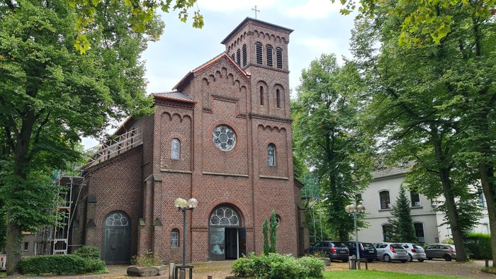 Antoniuskirche teilweise vom Dachdecker eingerüstet vom leerem Parkplatz aus fotografiert