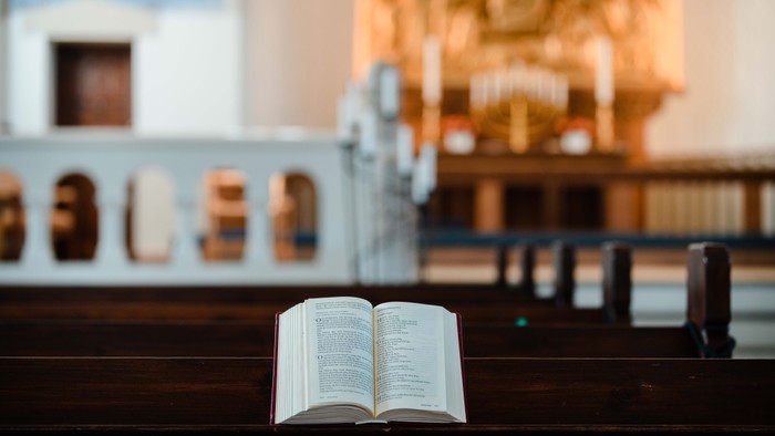 En åben bog på en træbæn ved et historisk sted