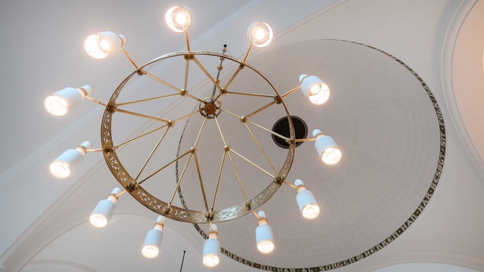 En stor, smuk kæmpelys med mange lysfader hænger fra loftet.