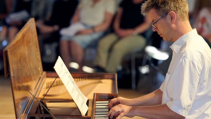 En mand spiller et instrument i en koncertsal.