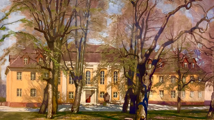 Ein charmantes historisches Gebäude, umgeben von kahlen Bäumen in einer ruhigen, parkähnlichen Umgebung.