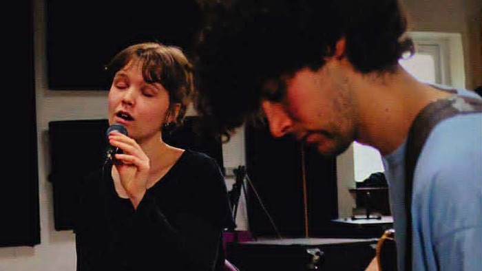 To personer, der spiller musikinstrumenter på scenen.