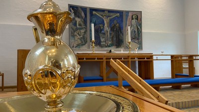 Kirkealter med gyldent alterbæger og religiøse malerier