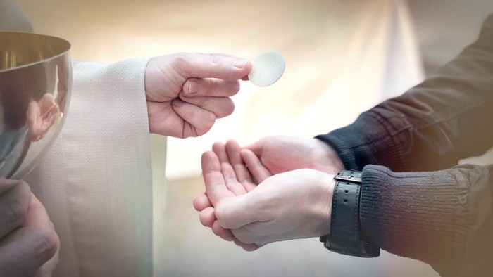 Zwei Personen reichen sich eine kleine Glasherz-Figur