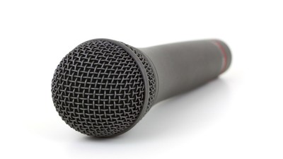 Et sort mikrofon med mesh foran på hvid baggrund