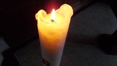 Eine brennende Kerze steht auf einem Tisch.