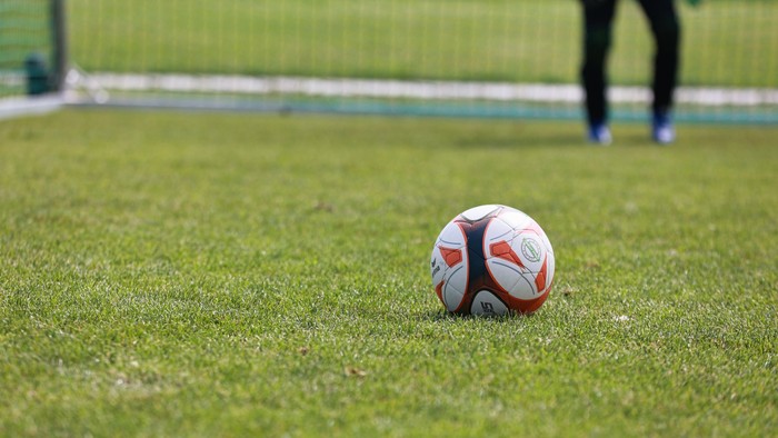 Ein Fußball liegt auf einem Fußballfeld.