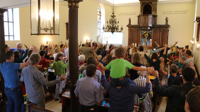 Eine Gruppe von Menschen singt in einer Kirche
