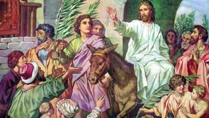 Jesus riding en hest inn i Jerusalem, omgivet af en folkemasse.
