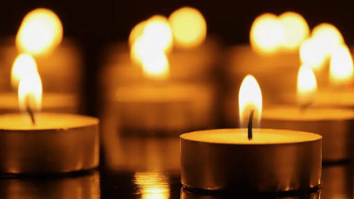 Warm beleuchtete Kerzen in enger Anordnung mit flackernden Flammen, die sanft leuchten.