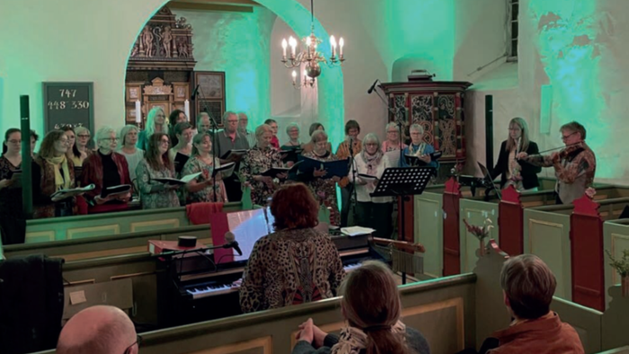 En kirkekor med flere sangere og en pianist under optagelse.