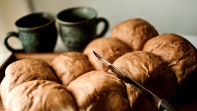 En brødstang med en kniv og to tæpper ved siden.
