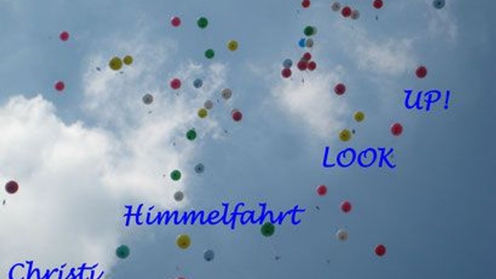 Farbenfrohe Luftballons schweben am Himmel, mit Botschaften wie 