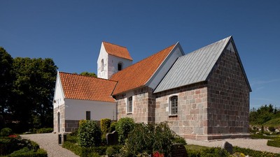 En lille kirke med røde tag og en tårn med klokke.