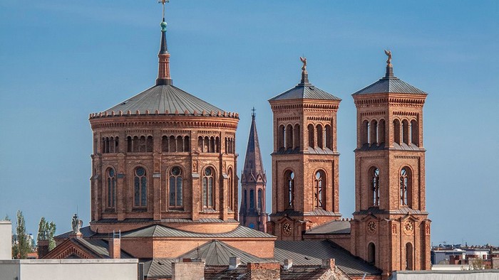 Große Kirche mit zwei Türmen und einer Kuppel, umgeben von kleineren Gebäuden.