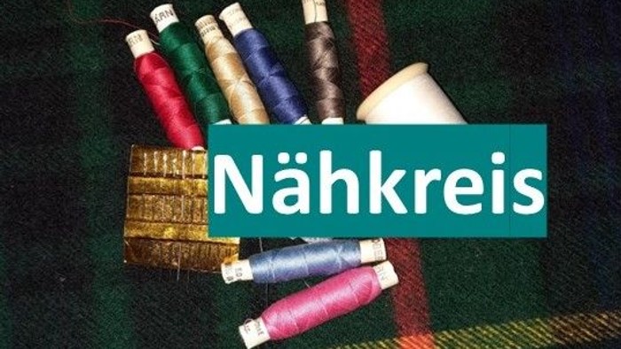 Bunte Garnrollen und Nähutensilien, arrangiert mit dem Wort „Nähkreis“, das auf eine Nähgruppe hinweist.