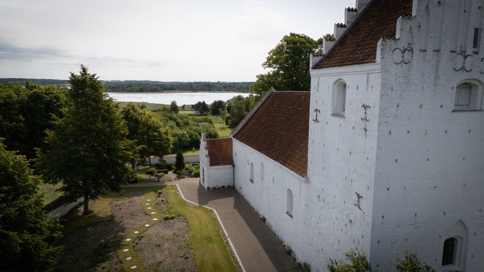 Et hvidt slot med røde tag ved en sø