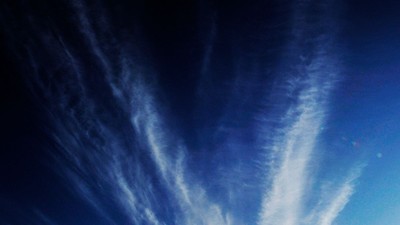 Himmelsk blå himmel med luftige, dramatiske skyer, der danner et slående, hvirvlende mønster.