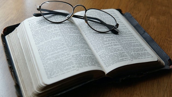 En åben bog med briller på.