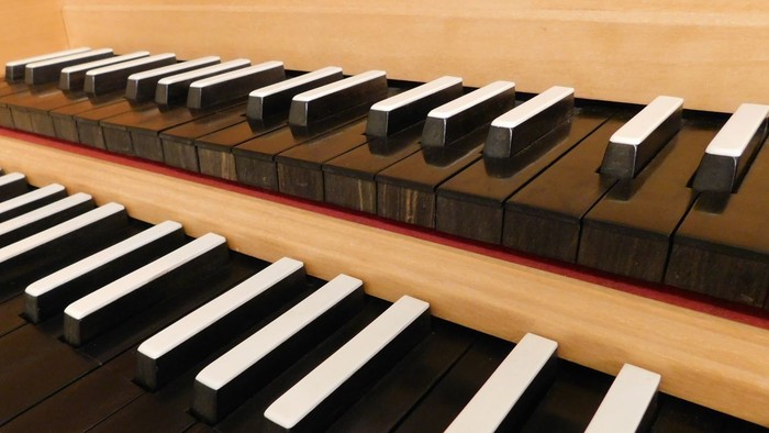 Nahaufnahme einer Klaviertastatur mit schwarzen und weißen Tasten auf einer Holzoberfläche.